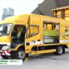 [ハイウェイテクノフェア 2021] 矢印板自動設置回収装置 搭載標準車「ロボアロー」 - 西日本高速道路メンテナンス九州株式会社